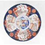 A large Japanese imari charger, Meiji period, in traditional blue and red palette with alternating
