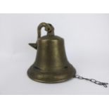 A brass ships style bell with a bracket and flower head ornament Location: