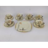 A Zenith Art Deco china tea set decorated with a windmill by a lake and tree comprising six cups,