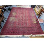 A hand woven Pakistani red ground rug having elephant foot motifs and tasselled ends 295cm x 203cm