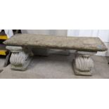 A reconstituted stone garden bench, on scrolled ends, 40cm high, 127cm wide Location: