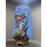 A Victorian blue pressed glass vase having hand painted decoration of a perched bird and foliage