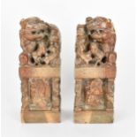 A pair of carved soapstone models of temple guardian Foo dogs, each modelled with a large dog and