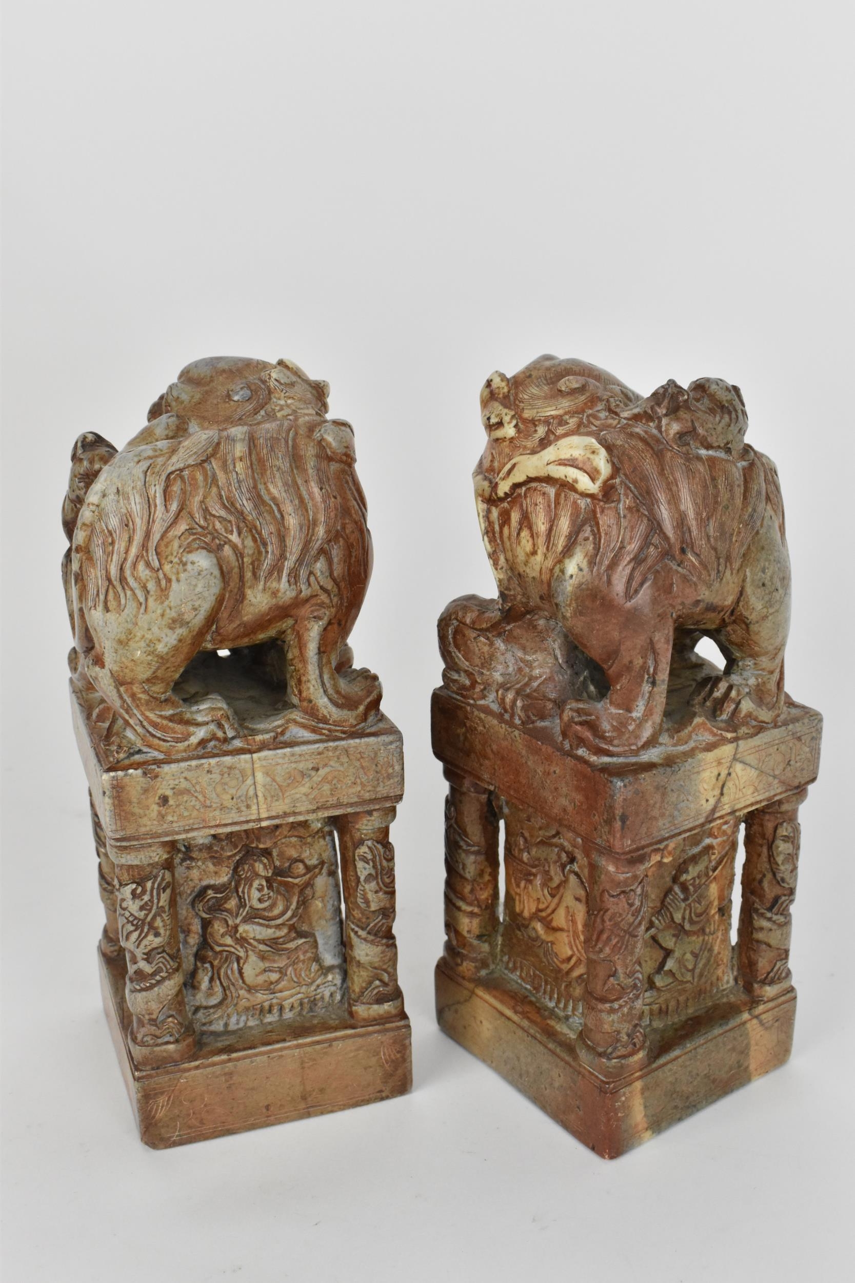 A pair of carved soapstone models of temple guardian Foo dogs, each modelled with a large dog and - Image 4 of 8