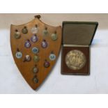 A collection of athletics medals, some silver enamel, on a shield shaped plaque, together with a