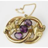 A Victorian Pinchbeck and amethyst brooch, the central three oval cut stones flanked by acanthus