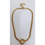 Christian Dior-A 1980's gold tone necklace having a central oval faux pearl pendant surrounded by