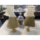 A group of five lamps to include a ceramic example, a pair of brass floral design lamps and two