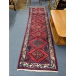 West Persian runner with eight diamond shaped gulls, on a red ground 300cm x 82cm Location:
