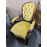 A Victorian mahogany salon armchair having button back upholstery and a carved scroll frame