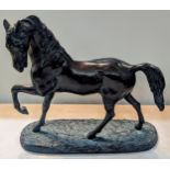 An Austin patinated cast metal model of a horse, on a naturalistic base Location: