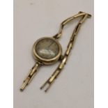 An early 20th century 9ct gold ladies manual wind watch on a gold plated expanding bracelet,