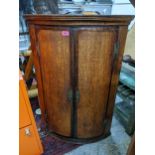 A Georgian oak bow fronted corner wall hanging cabinet, 95h x 67.5w, Location: