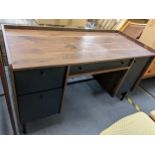 A modern walnut finished desk having drawers and cupboards, standing on metal turned legs, 80h x