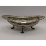 An Edwardian silver pierced dish having a gadrooned rim and raised on four feet, hallmarked