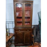 A Victorian mahogany bookcase cabinet with a pair of glazed doors over a drawer and a pair of doors,