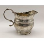 A late Victorian silver milk jug having a wavy cut rim, hallmarked London 1900, 121g, Location: