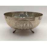 A white metal bowl decorated with three embossed roundels and stamped silver 830