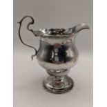 An early 20th century silver cream jug having a crimped edge and base, 105.4g, Location: