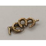 A 9ct gold brooch fashioned as three horseshoes and a riding crop, 1.7g, Location:
