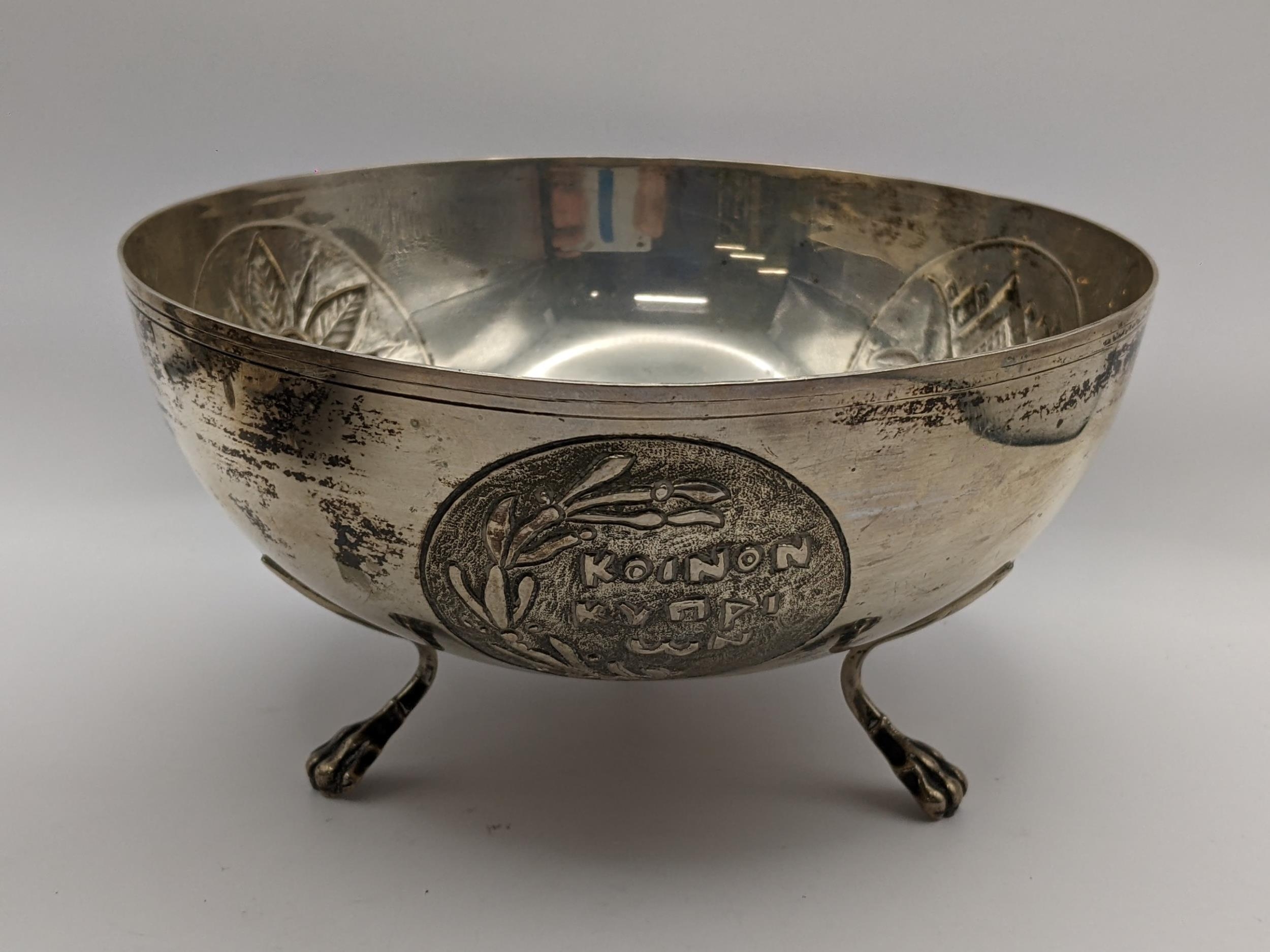 A white metal bowl having embossed decoration, engraving and on three feet, 266g, Location: