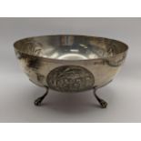 A white metal bowl having embossed decoration, engraving and on three feet, 266g, Location: