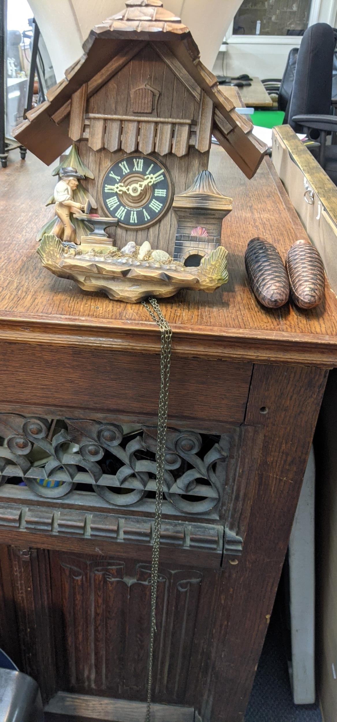 A vintage Black Forest Cuckoo clock in the style of architectural form, together with two weights