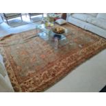A Zeglar design hand knotted woollen rug with repeated pelmets and vine motifs on a green ground,