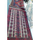 A Persian design rug on a red ground, an Afghan rug and a machine made mat.