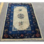 A Chinese handwoven Peking rug having a central motif and a floral border 180cm x 118cm Location: