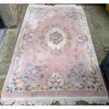 A Chinese pink ground rug having a central motif and a floral design, 250c,m x 153cm Location: