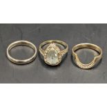 Three 9ct gold rings, one set with ten diamonds, a wedding ring and another with aquamarine style