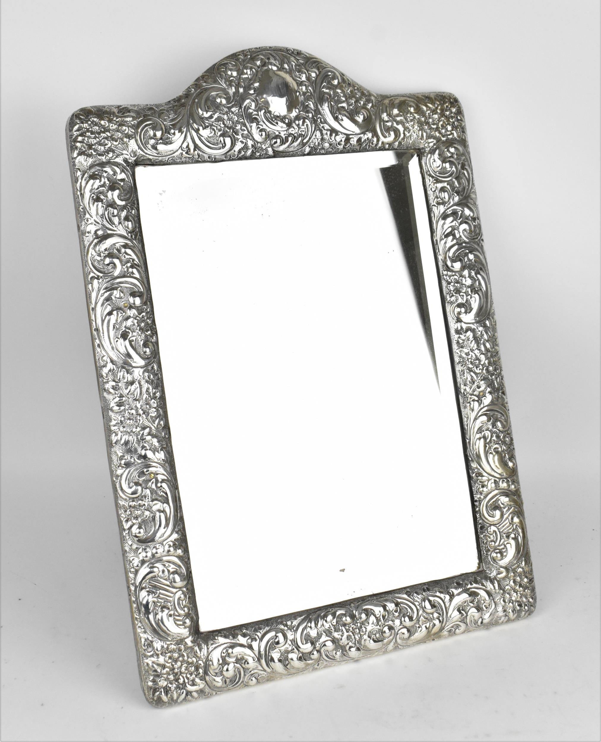 An Edwardian silver mounted dressing table mirror, Birmingham 1904, the frame with embossed c-