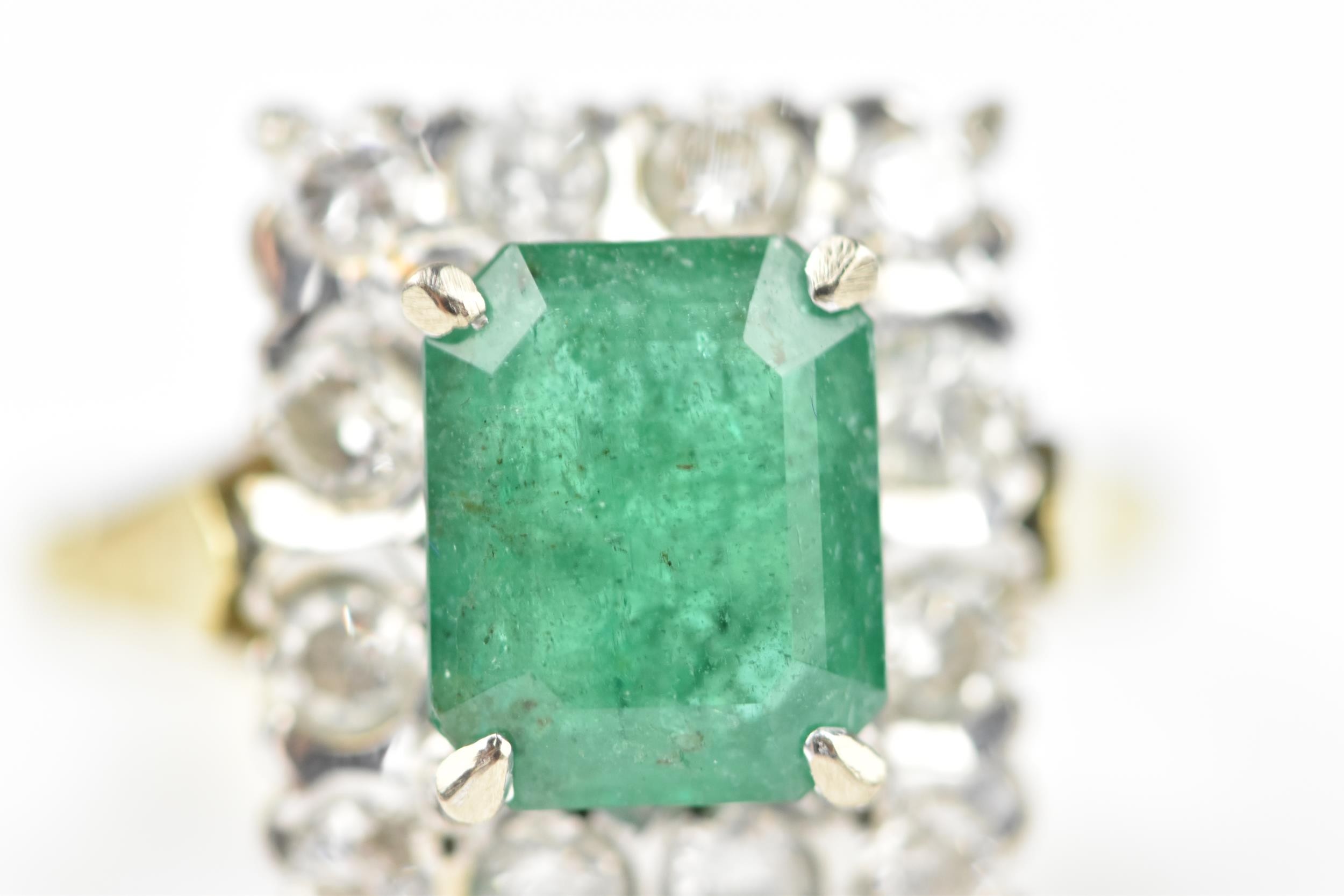 An 18ct yellow gold, emerald and diamond dress ring, with central step cut emerald in a halo of - Image 9 of 11