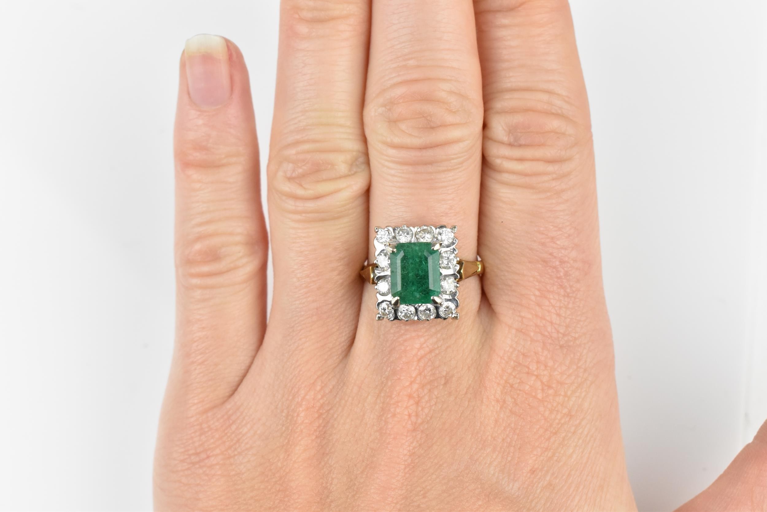 An 18ct yellow gold, emerald and diamond dress ring, with central step cut emerald in a halo of - Image 11 of 11