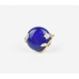 A 9ct yellow gold, diamond and lapis lazuli dress ring, the circular cabochon polished stone mounted