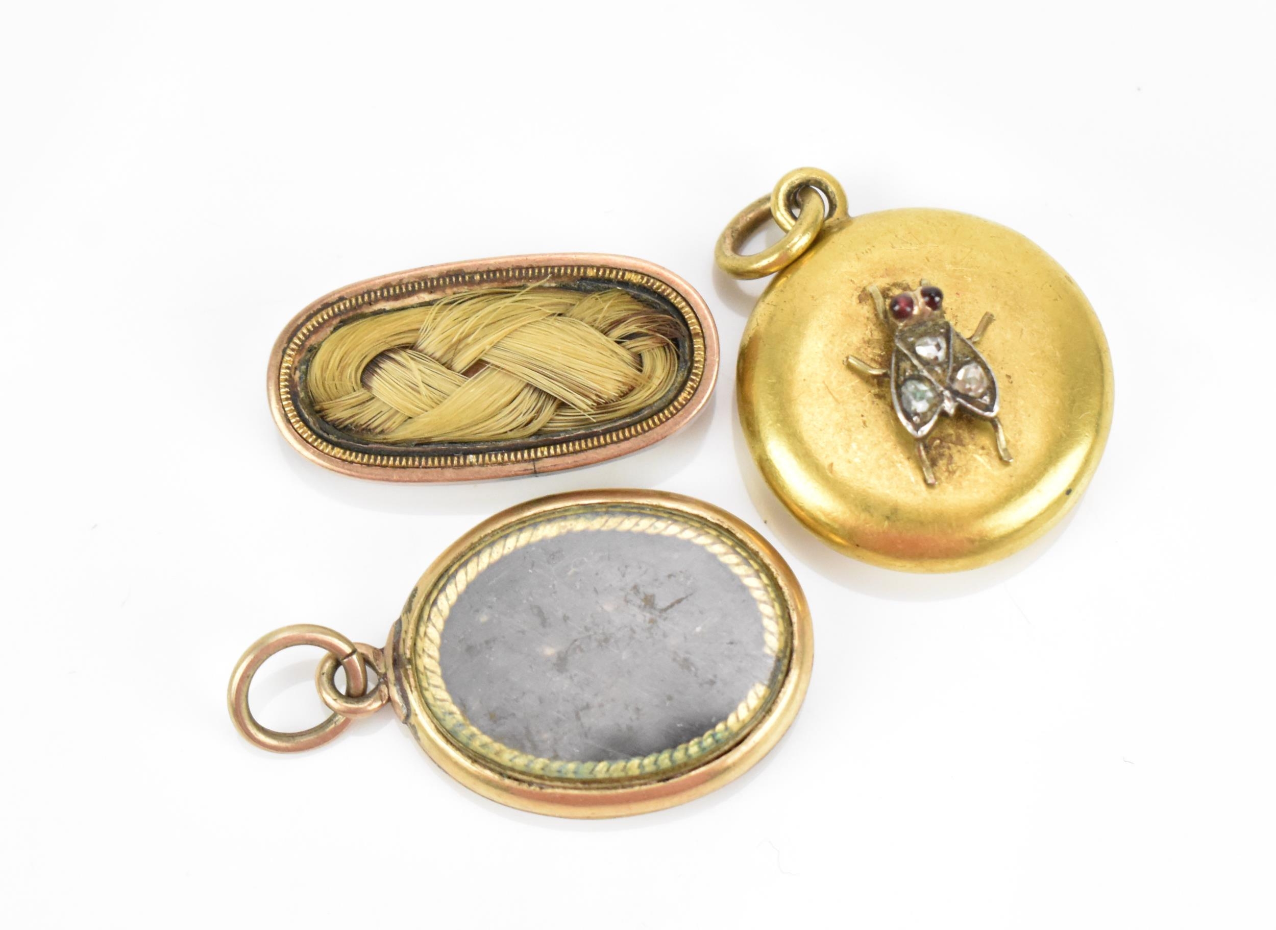 Two Victorian mourning pendants and a brooch, comprising two with braided hair, the third one with