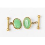 A pair of yellow metal and jade cuff links, with central oval cabochon green jade in a yellow