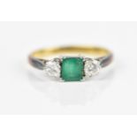 An 18ct yellow gold, platinum, emerald and diamond ring, with central princess cut emerald,