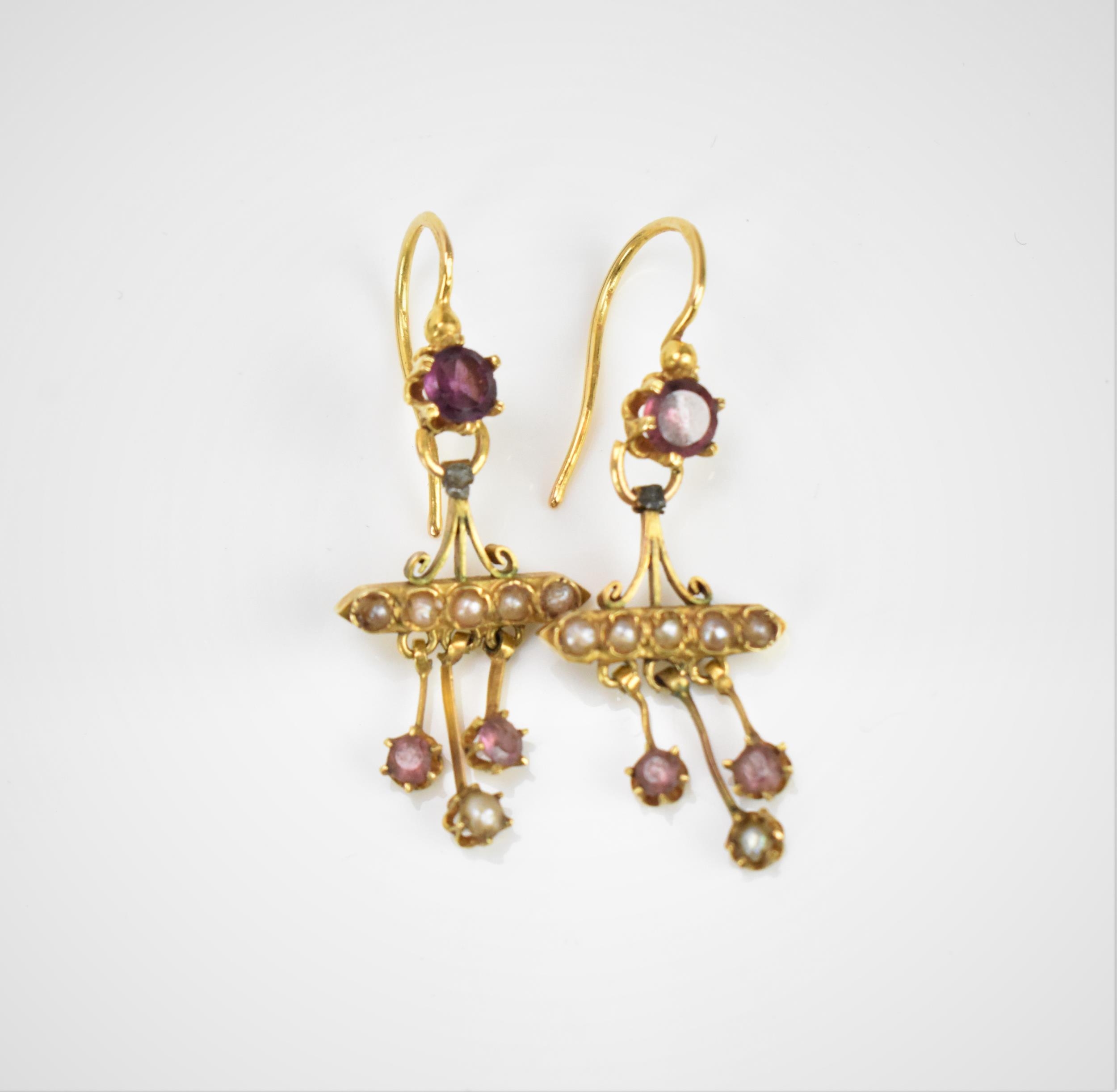 A pair of Victorian yellow metal, seed pearl and amethyst earrings, with central round cut