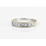 An 18ct white gold and diamond half eternity ring, with seven pave set princess cut diamonds, size