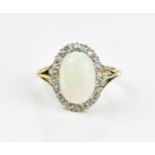An 18ct white and yellow gold, white opal and diamond dress ring, with central solid opal cabochon