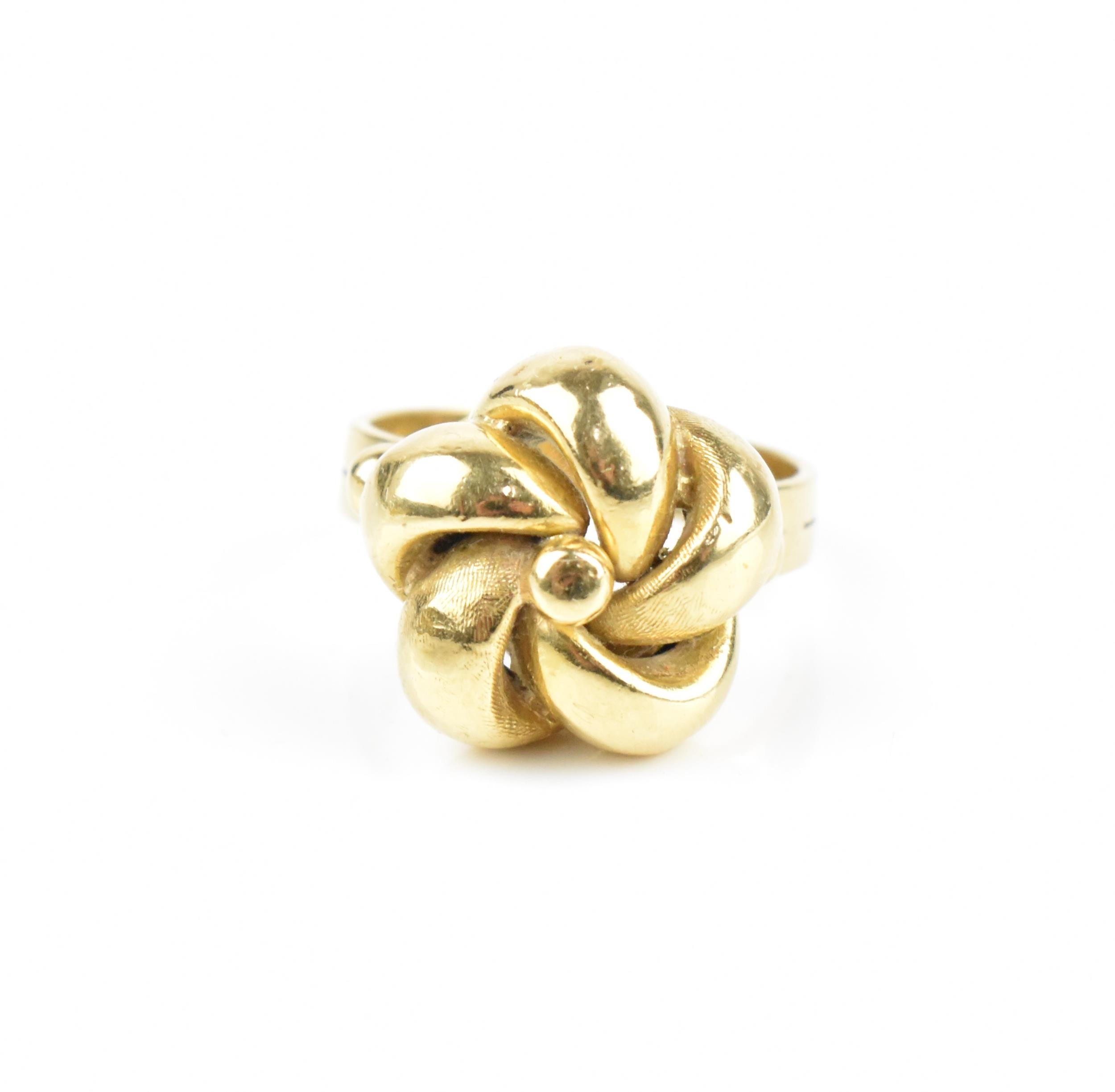 An 18ct yellow gold ring designed as a knot, with pierced loops, the double-ring shank stamped