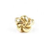 An 18ct yellow gold ring designed as a knot, with pierced loops, the double-ring shank stamped