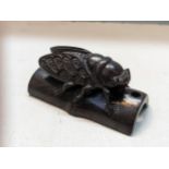 A Japanese treen carved netsuke of a Cicada perched on bamboo Location: