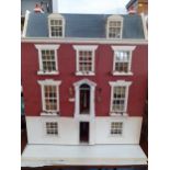 A 20th century doll's house in the form of a Georgian house with electrical lighting, and a small