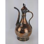An 18th century Persian copper and brass Dallah, with a hinged lid on curved spout, 36cm high,