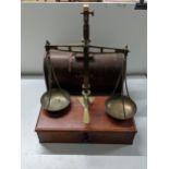 A late Victorian mahogany and brass balance with a pair of pans and various sets of weights, a