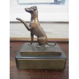 A Hearing Dogs for the Deaf bronze sculpture of a seated dog with left paw raised, mounted on a