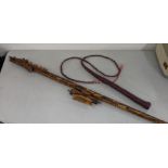 A carved bone dragon style blow pipe, 126cm long, together with a vintage leather whip Location: